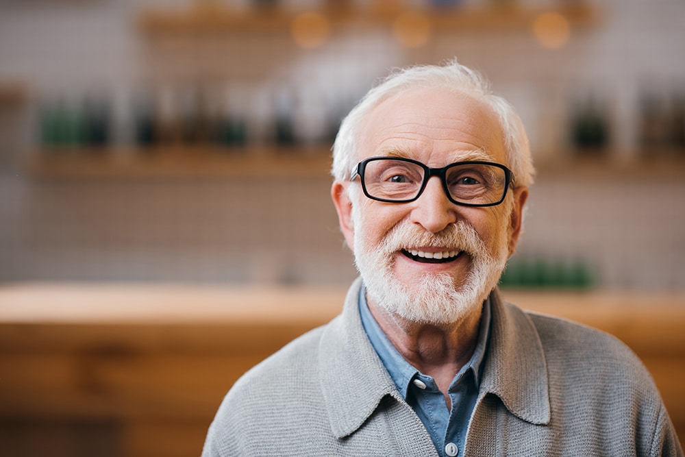 close-up portrait of happy senior man looking at camera