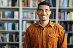 Man standing in library smiling
