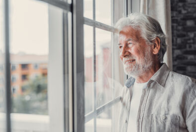 Older man looks out window