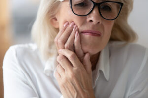 Woman with mouth pain in glasses