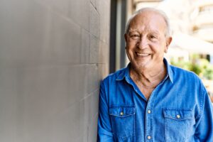 Senior man leaning against wall