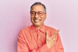 Man wearing salmon shirt in glasses smiling