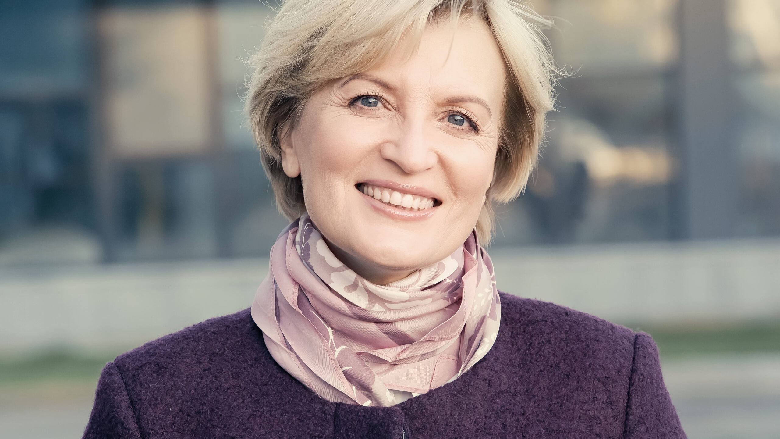 smiling middle aged woman in neckerchief looking at camera outdoors,stock image